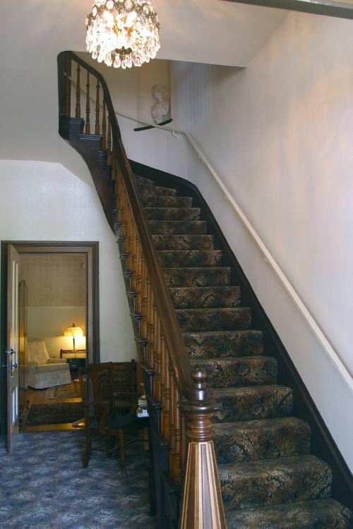 Stairs from the foyer to the second-floor Isabella Suite
